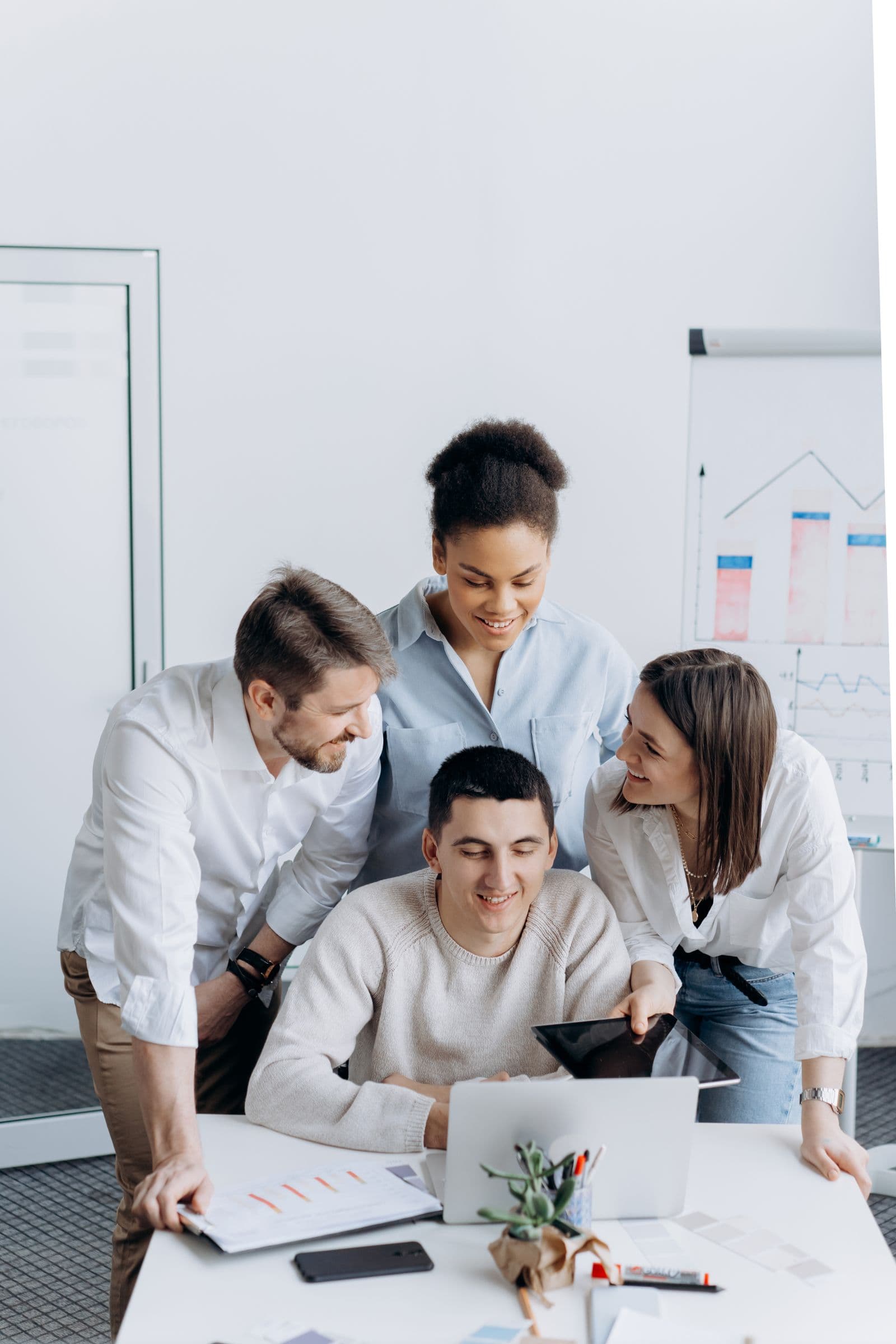 A small team reviewing work around a laptop